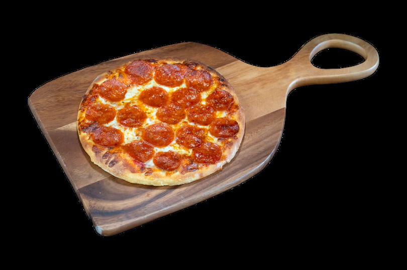 A small, round pepperoni pizza with melted cheese on a wooden pizza peel.